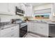 Well-lit kitchen with modern appliances, granite counters, and stylish white cabinetry at 4568 67Th N St, St Petersburg, FL 33709