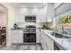 Updated kitchen featuring stainless steel appliances, granite countertops, and sleek white cabinets at 4568 67Th N St, St Petersburg, FL 33709