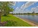 Scenic backyard view with lush green lawn, a tranquil lake, and mature trees at 4811 Sandy Glen Way, Wimauma, FL 33598