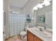 Bathroom with a single vanity, shower with curtain, and neutral tile flooring at 4811 Sandy Glen Way, Wimauma, FL 33598