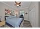 Comfortable bedroom with a queen-size bed, modern art, and gray wood flooring at 4811 Sandy Glen Way, Wimauma, FL 33598