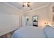 Bedroom featuring a queen-sized bed, large closet, and stylish decor, with gray wood floors at 4811 Sandy Glen Way, Wimauma, FL 33598