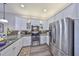 Kitchen features stainless steel appliances and granite countertops with bright white cabinets at 4811 Sandy Glen Way, Wimauma, FL 33598