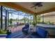 Screened lanai with comfortable seating overlooking a serene lake view and includes a hot tub at 4811 Sandy Glen Way, Wimauma, FL 33598
