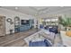 Bright living room with wood floors, comfortable seating, and views of the lanai at 4811 Sandy Glen Way, Wimauma, FL 33598
