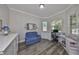 Bright office space with gray wood floors, white cabinets and trim, and a comfortable blue couch at 4811 Sandy Glen Way, Wimauma, FL 33598