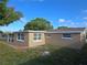 Backyard view of the tan home under a clear blue sky at 5130 Tilson Dr, New Port Richey, FL 34652