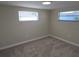 Cozy bedroom with neutral carpet, two windows for natural light, and light neutral-colored walls at 5130 Tilson Dr, New Port Richey, FL 34652