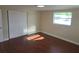 Bedroom with wood flooring, white walls, closet with sliding doors, and a window overlooking the exterior at 5130 Tilson Dr, New Port Richey, FL 34652