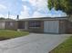 Front exterior with large driveway and a two-car garage at 5130 Tilson Dr, New Port Richey, FL 34652