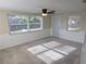 Bright living room with plush carpet, wainscoting detail, and plenty of natural light from the many windows at 5130 Tilson Dr, New Port Richey, FL 34652