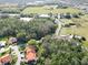 Expansive aerial perspective showcasing a home nestled among lush greenery, a tranquil lake, and the surrounding landscape at 5454 Saddlebrook Way # 2, Wesley Chapel, FL 33543