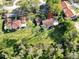 A stunning aerial view showcases the property amidst a sprawling, green lawn surrounded by lush trees at 5454 Saddlebrook Way # 2, Wesley Chapel, FL 33543