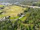 Aerial view overlooking a lush golf course, scenic roads, and nearby homes surrounded by dense woodlands at 5454 Saddlebrook Way # 2, Wesley Chapel, FL 33543