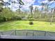 A beautiful, well-maintained lawn stretches out beyond the screened-in balcony, adorned with mature trees at 5454 Saddlebrook Way # 2, Wesley Chapel, FL 33543