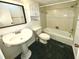 Cozy bathroom featuring a pedestal sink, tile shower, and retro tile flooring at 5454 Saddlebrook Way # 2, Wesley Chapel, FL 33543