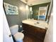 Cozy bathroom with a white vanity, a framed mirror, and unique decorative art at 5454 Saddlebrook Way # 2, Wesley Chapel, FL 33543