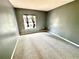 A gray-painted bedroom with a cozy carpet and a window that provides natural light at 5454 Saddlebrook Way # 2, Wesley Chapel, FL 33543