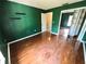 A green-painted bedroom with hardwood floors and a door that leads to another room at 5454 Saddlebrook Way # 2, Wesley Chapel, FL 33543