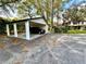 Carport featuring a vehicle, with partial garage storage and driveway at 5454 Saddlebrook Way # 2, Wesley Chapel, FL 33543
