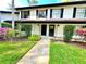 Charming townhouse entrance with landscaped garden and black shutters and doors at 5454 Saddlebrook Way # 2, Wesley Chapel, FL 33543