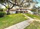 Inviting two-story home with a lush green lawn and mature trees draped with Spanish moss at 5454 Saddlebrook Way # 2, Wesley Chapel, FL 33543