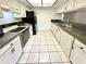 Bright kitchen featuring white cabinets, black appliances, and tile flooring at 5454 Saddlebrook Way # 2, Wesley Chapel, FL 33543