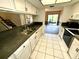 Bright kitchen features white cabinets, stainless steel sink, and a view of the patio at 5454 Saddlebrook Way # 2, Wesley Chapel, FL 33543