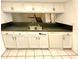 Clean, updated kitchen with white cabinetry, grey countertops, and modern appliances at 5454 Saddlebrook Way # 2, Wesley Chapel, FL 33543