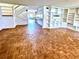 Open living room featuring unique parquet flooring, built-in shelves, and staircase access at 5454 Saddlebrook Way # 2, Wesley Chapel, FL 33543