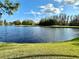 Lakeside community view with pond and verdant grass at 5454 Saddlebrook Way # 2, Wesley Chapel, FL 33543