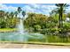 Scenic pond with a fountain, lush greenery, and palm trees in a tranquil community setting at 5454 Saddlebrook Way # 2, Wesley Chapel, FL 33543