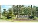 Entrance sign for Saddlebrook surrounded by lush landscaping and mature trees at 5454 Saddlebrook Way # 2, Wesley Chapel, FL 33543