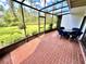 View of screened patio with brick flooring, seating, and lush backyard views at 5454 Saddlebrook Way # 2, Wesley Chapel, FL 33543