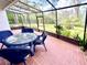 Screened patio with outdoor seating, brick flooring and a view of the backyard at 5454 Saddlebrook Way # 2, Wesley Chapel, FL 33543