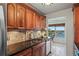 Kitchen featuring wood cabinets, granite countertops, stainless steel sink, and a stunning water view at 6075 Shore S Blvd # 509, Gulfport, FL 33707