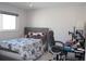 Bright bedroom featuring a gray upholstered headboard, floral bedding, and a desk with an office chair at 6225 Imperial Ky, Tampa, FL 33615