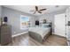 Cozy bedroom features a ceiling fan, wood flooring, and a large window at 6511 Senegal Palm Way, Apollo Beach, FL 33572