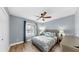 Comfortable bedroom features a ceiling fan, wood flooring, and an accent wall at 6511 Senegal Palm Way, Apollo Beach, FL 33572