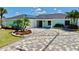 Exterior of a charming light blue home featuring a new driveway, manicured landscaping and a one car garage at 6511 Senegal Palm Way, Apollo Beach, FL 33572