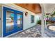 Inviting front porch featuring a striking blue double door and stylish brick flooring at 6511 Senegal Palm Way, Apollo Beach, FL 33572