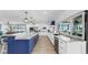 Bright, modern kitchen with stainless steel appliances, blue island, and natural light at 6511 Senegal Palm Way, Apollo Beach, FL 33572