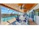 Covered lanai with a dining table overlooking the pool and waterfront views at 6511 Senegal Palm Way, Apollo Beach, FL 33572