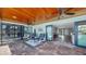 Enclosed patio with brick floors, ceiling fans, and furniture at 6511 Senegal Palm Way, Apollo Beach, FL 33572