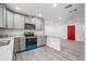Modern kitchen with gray cabinets, stainless steel appliances, and light countertops, seamlessly connected to the living area at 7249 Berry Rd, Zephyrhills, FL 33540