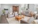 Sun-lit living room featuring contemporary furnishings, a brick accent wall, and an open layout to the kitchen at 7249 Berry Rd, Zephyrhills, FL 33540