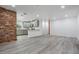 Open concept living space with views of the recently renovated kitchen and brick accent wall at 7249 Berry Rd, Zephyrhills, FL 33540