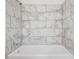 Shower tub featuring neutral tile walls and shower faucet at 7249 Berry Rd, Zephyrhills, FL 33540