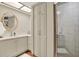 Bright bathroom with tiled shower, white vanity, and skylight at 7591 Harbor View Way, Seminole, FL 33776