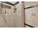 Shower with tile and black trim, featuring a niche, shower head, and translucent knob at 7591 Harbor View Way, Seminole, FL 33776